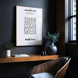 Motivational art for the office with minimalist black text on white in a dark wall room with a wooden shelf and plants