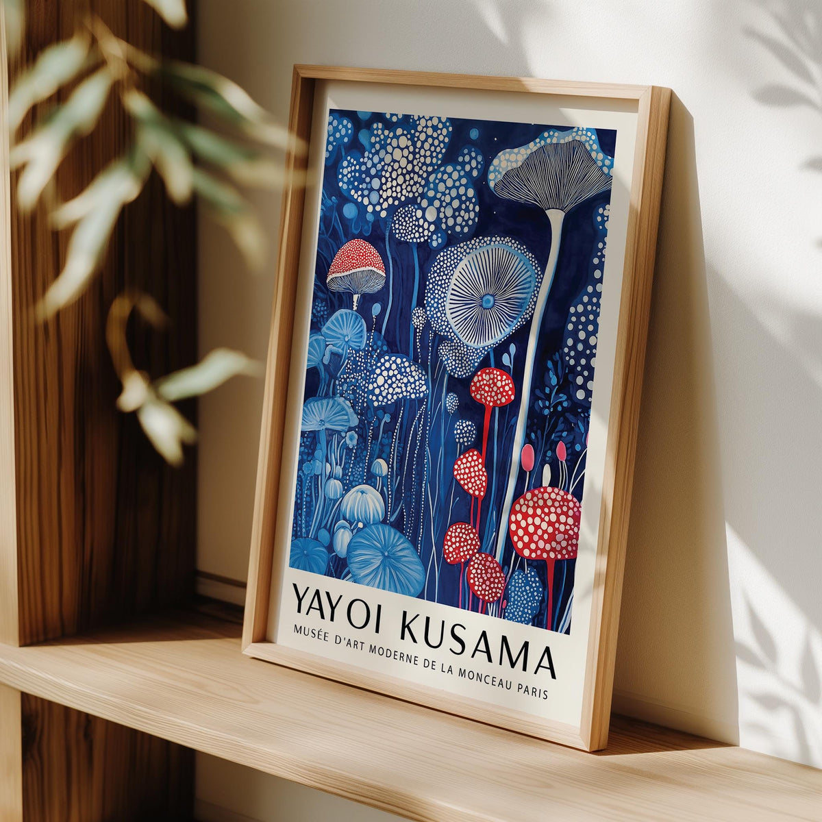 Framed Mushroom Print leaning on a wooden shelf with red and blue mushrooms and dots
