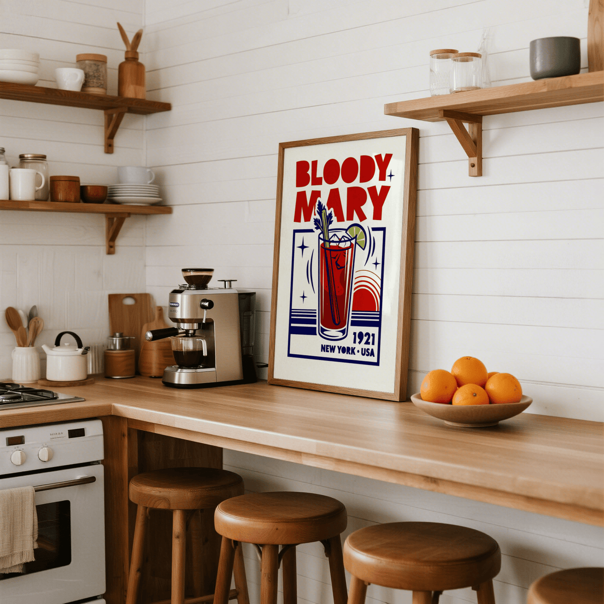 Bloody Mary Poster leaning on kitchen counter near a coffee machine and a bowl of oranges