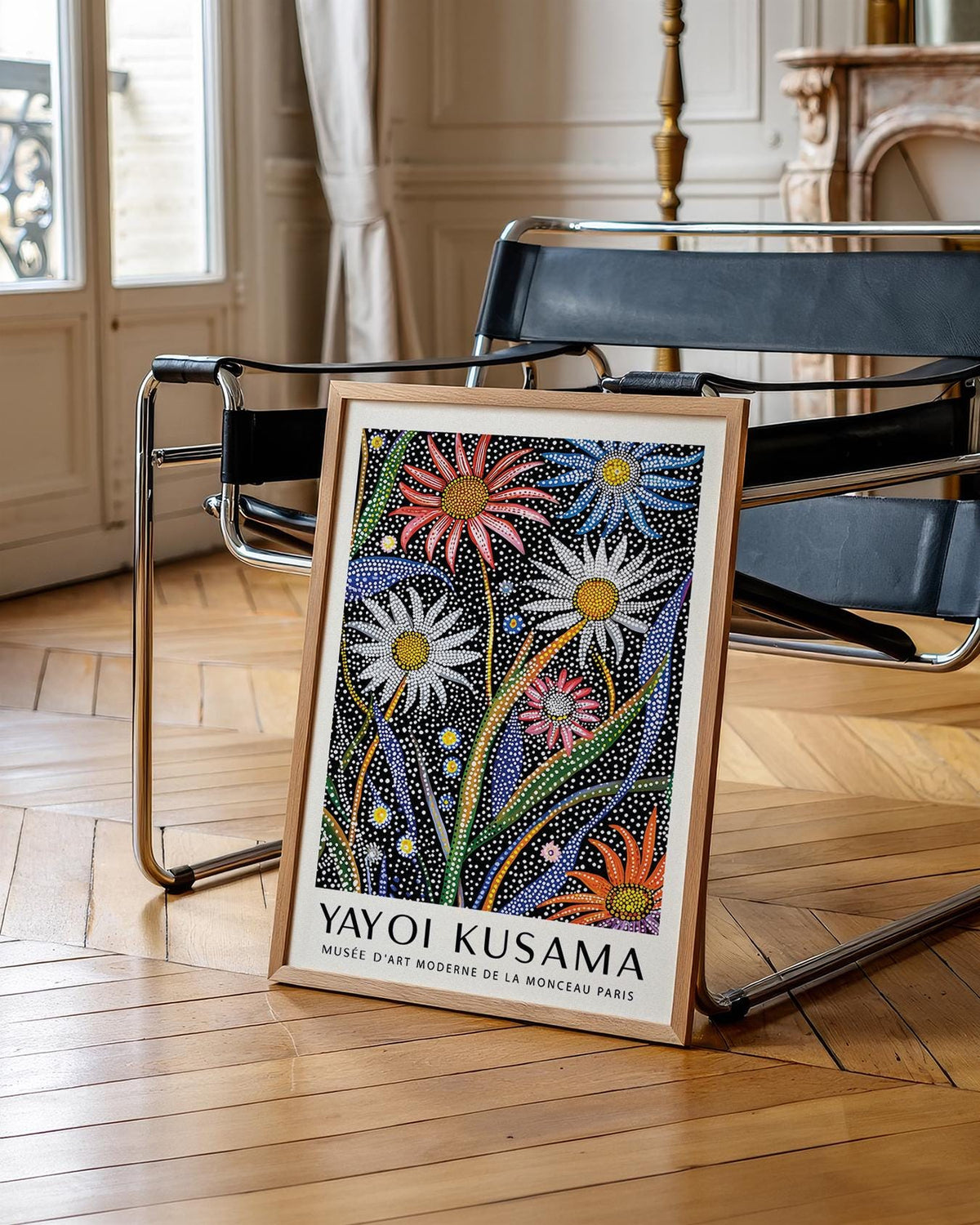 Abstract Botanical wall art with dotted flowers and green leaves leaning on a modern black chair