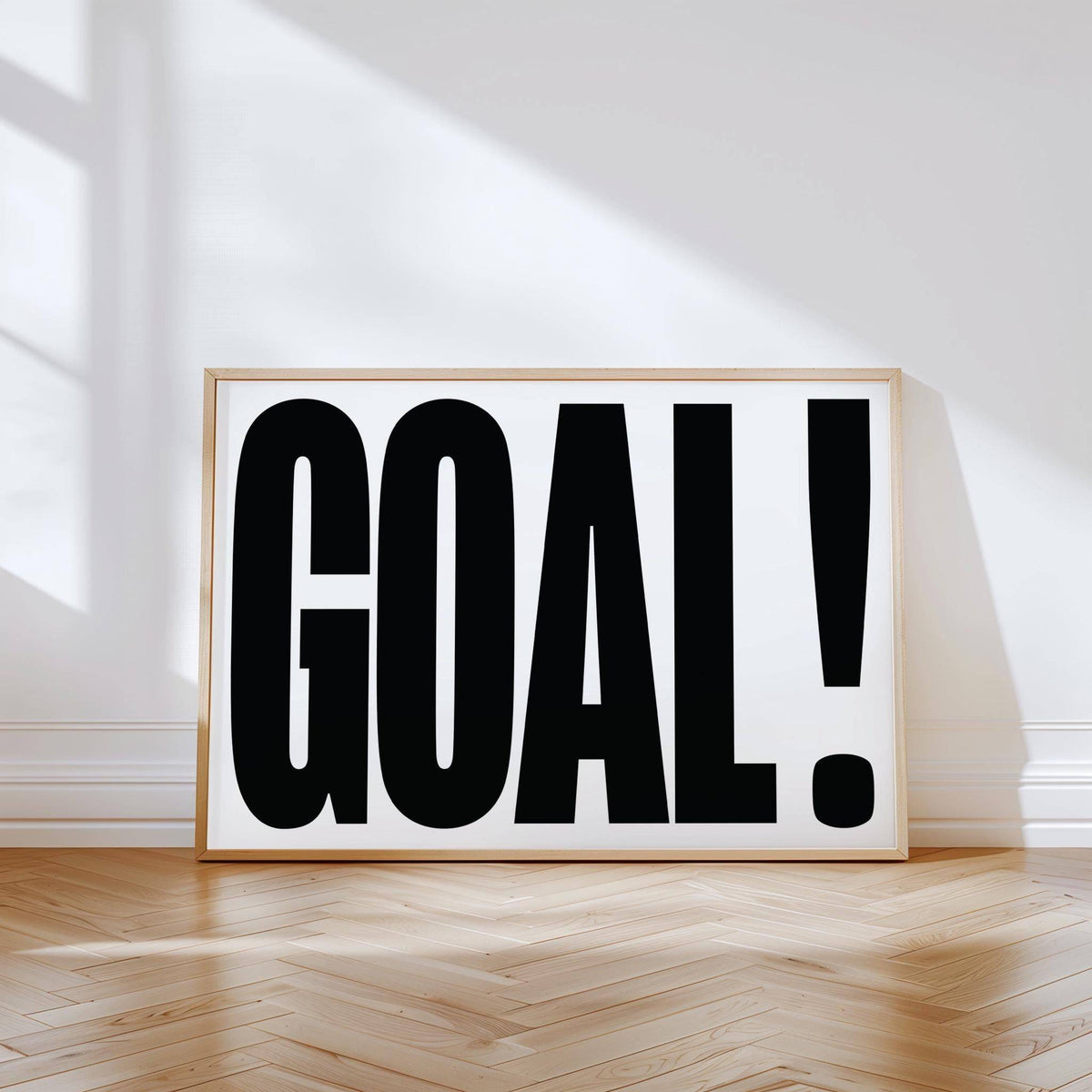 Wall Art for Games Room typographic word GOAL in bold black letters leaning on wooden floor against a white wall