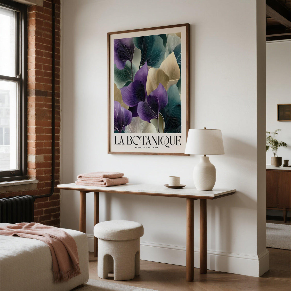 Leaf Art Prints hanging above a console table with a white lamp in a bedroom with brick and white walls