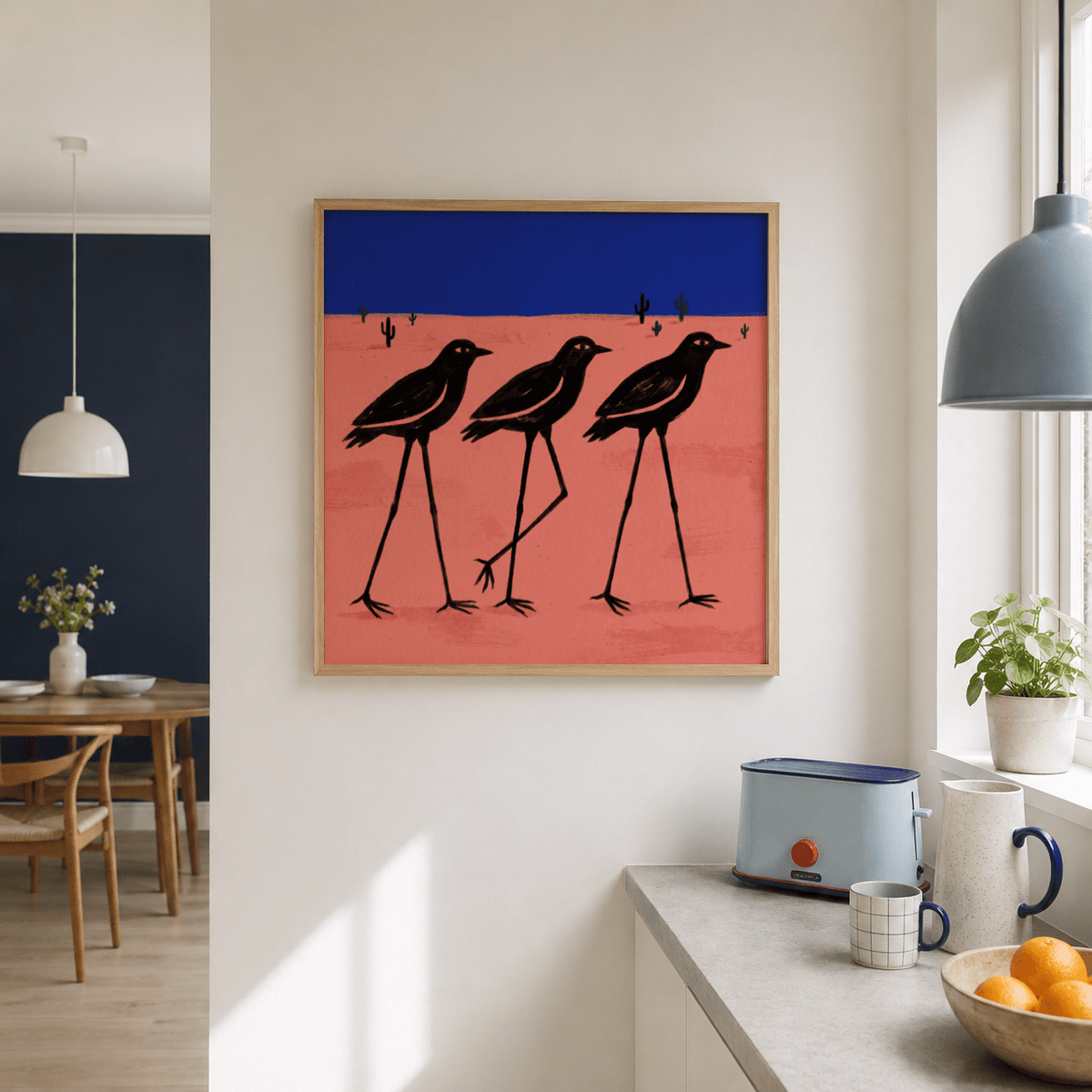 Desert Bird wall art with stylised black birds on a pink ground and blue sky in a kitchen above a toaster