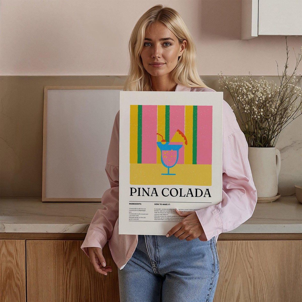 Wall Art for Kitchen held by woman showing piña colada cocktail in pink yellow and green