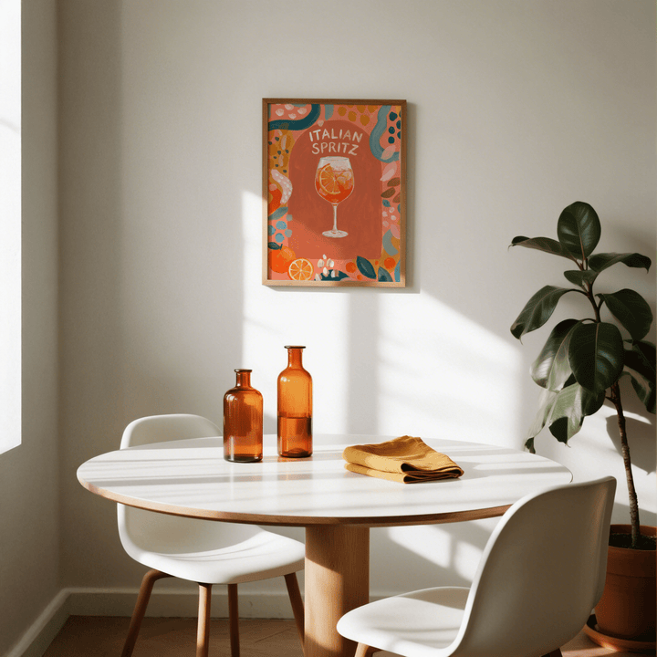 Italian Spritz Art Print framed on a wall above a dining table with amber bottles and a potted plant