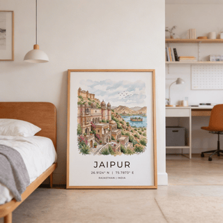 Jaipur art print leaning on the floor with a brown bed frame and grey blanket nearby in a bedroom