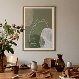 Modern Organic Print leaning on a dining room wall with green and beige abstract shapes and tableware below