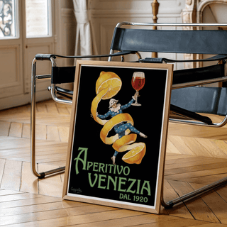 Vintage Aperitivo Print leaning on a wooden floor black chair beside a brass lamp