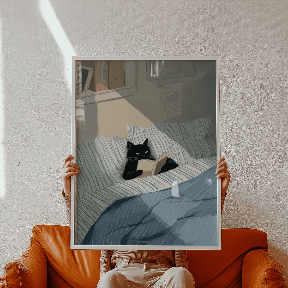 Framed Cat Reading Book Wall Art held on an orange chair with a brown and blue bed scene