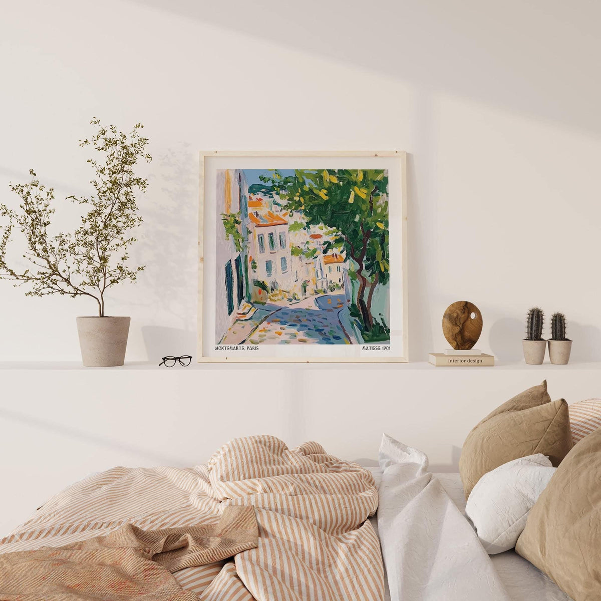 Print on a wall in a bedroom French Artwork Prints of Paris street with green tree and warm colours with cushions