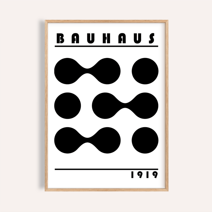Framed minimalist geometric print with black abstract shapes and text in a light wooden frame