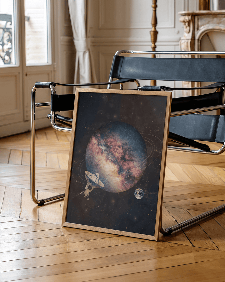 Cosmic art print leaning on a modern black chair showing an abstract space planet with satellite dish