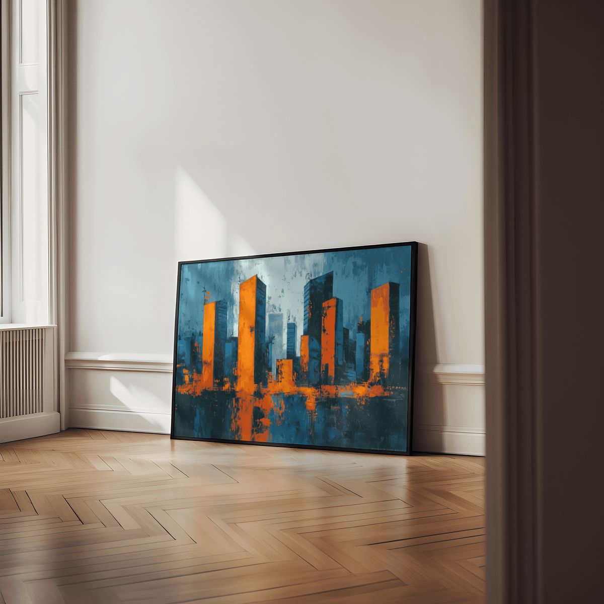 Cityscape wall art leaning on floor with orange and blue abstract buildings in a bright room