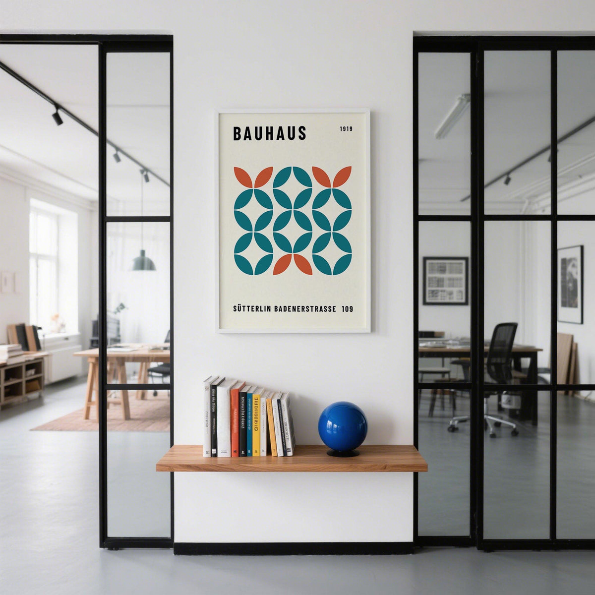 Work office wall art in a minimalist office space with a shelf holding books and a blue sphere