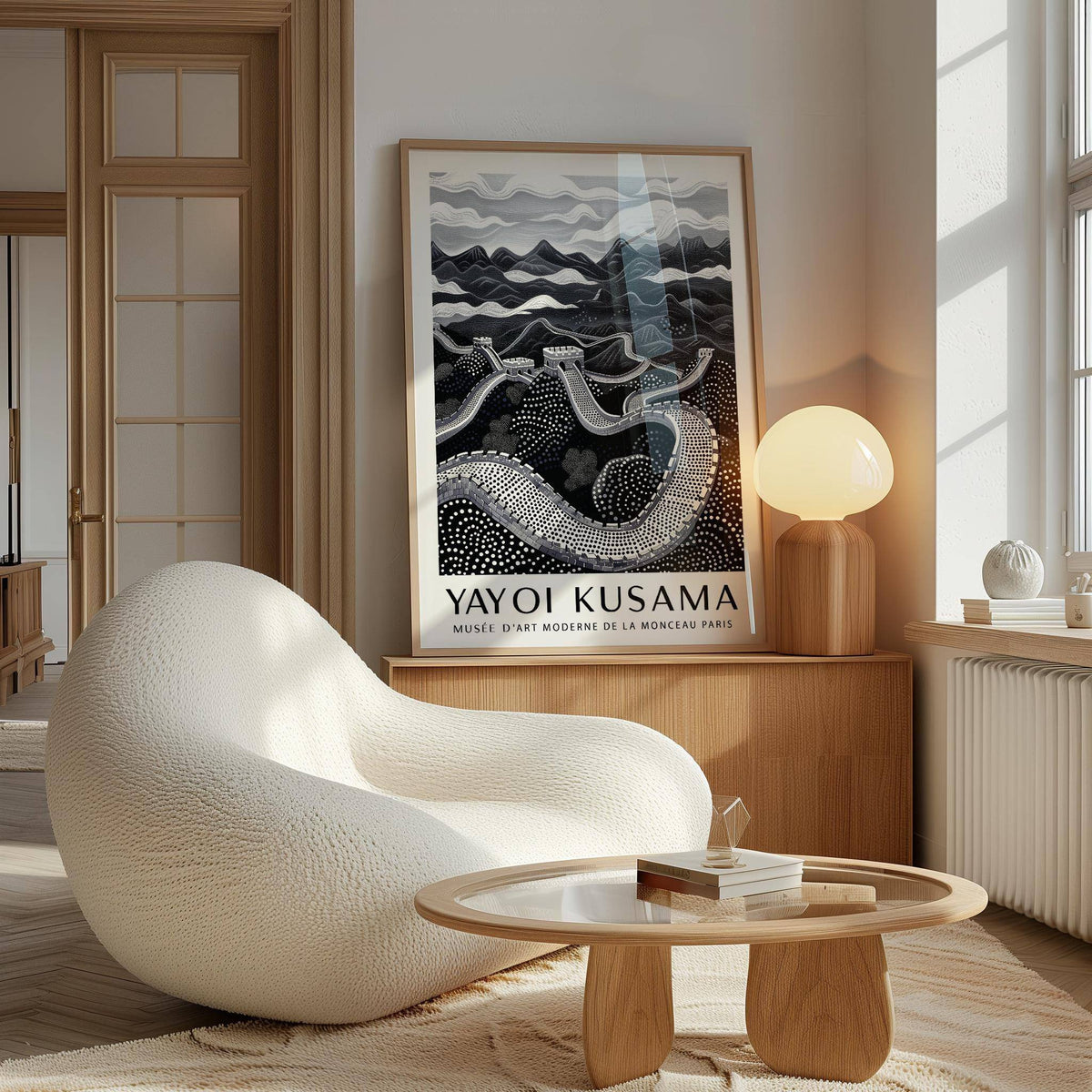 Chinese wall art print leaning on a wooden sideboard with a lamp and a smooth white chair nearby