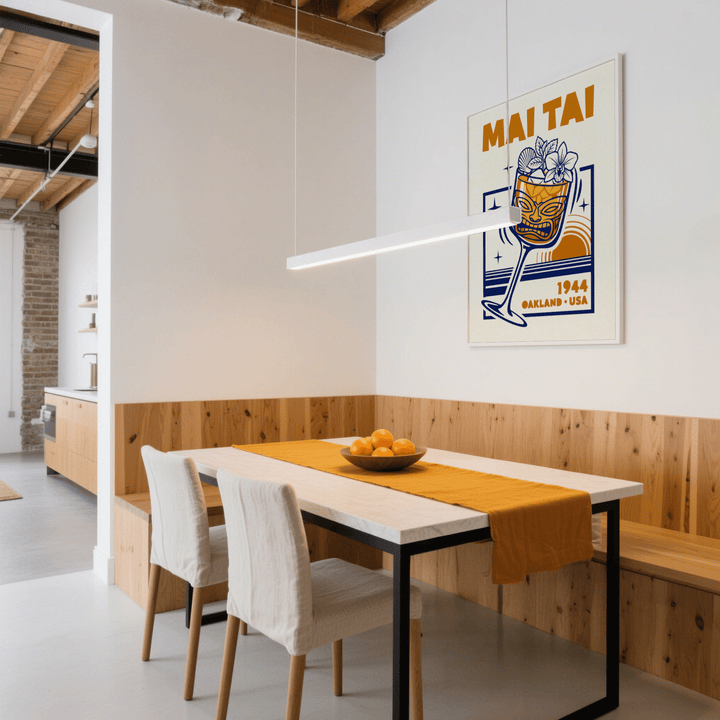 Mai Tai wall art retro illustration in orange and navy hung above a dining table with an orange runner