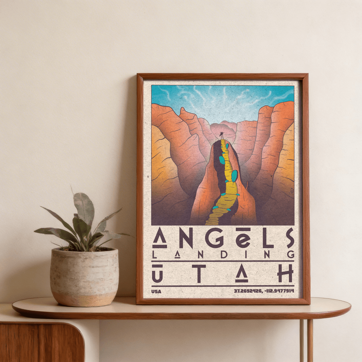 Framed Zion National Park art illustrating Angels Landing mountain trail in warm vintage colours on a wooden table with plant