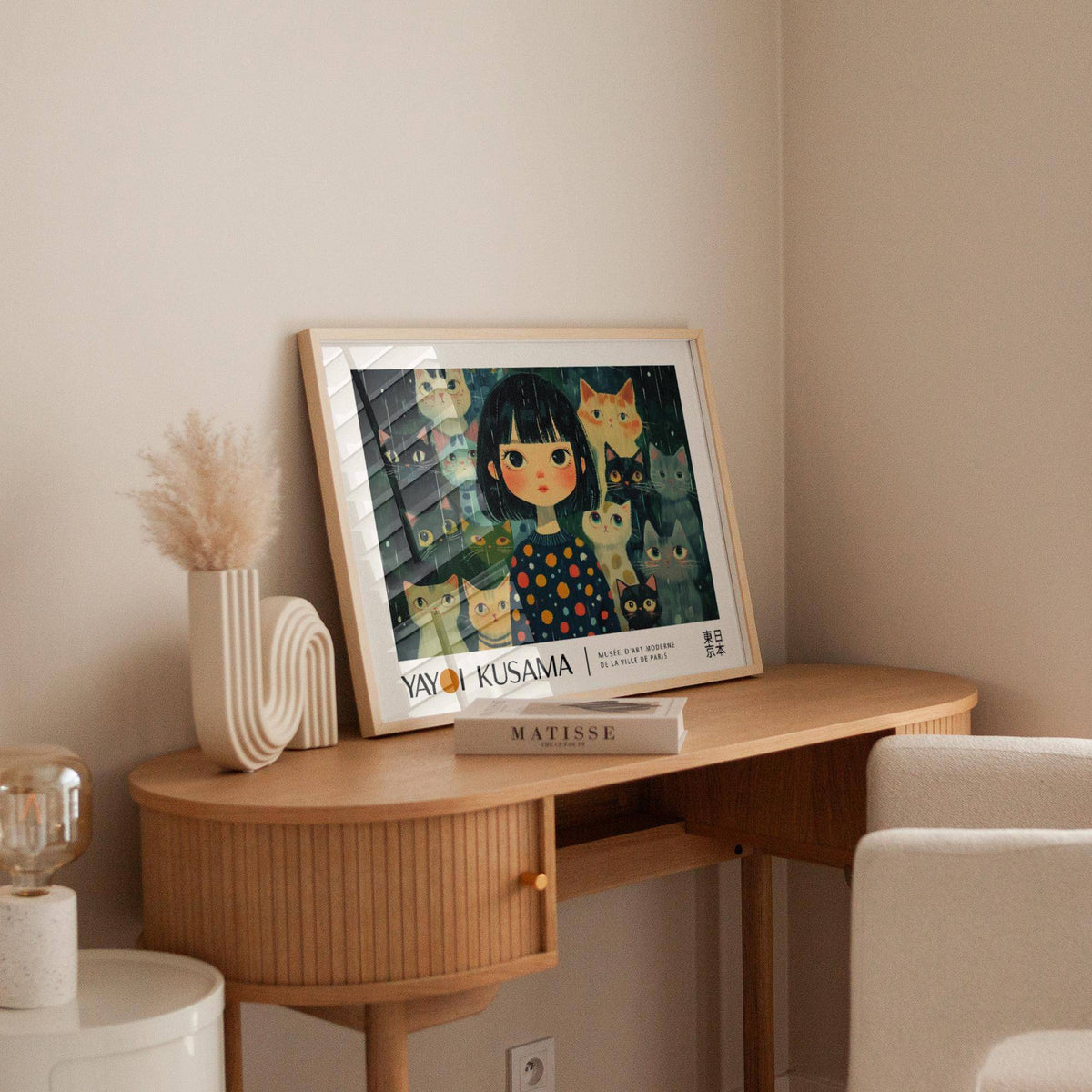 Unique Wall Art print leaning on a wooden desk with a beige vase and cream chair nearby