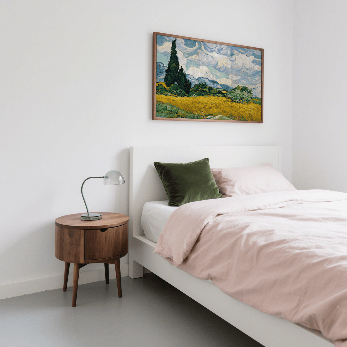 Framed Cypress Tree Landscape print above a white bed with pink bedding and a green cushion in a bedroom