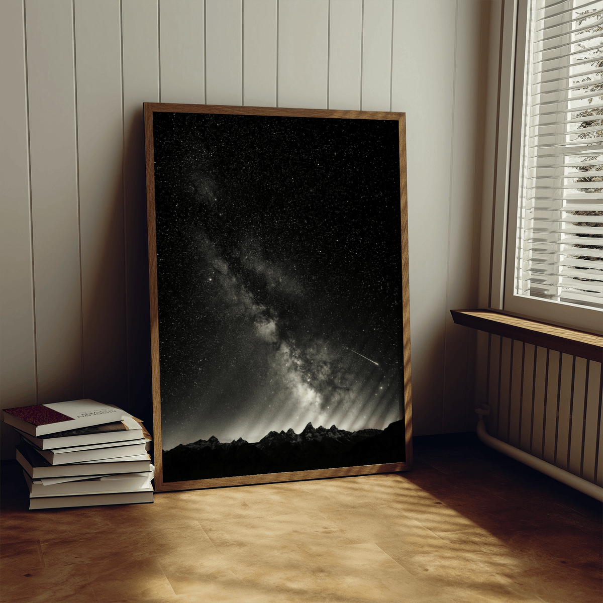 Starry Night Poster leaning on a floor next to stacked books in a softly lit room