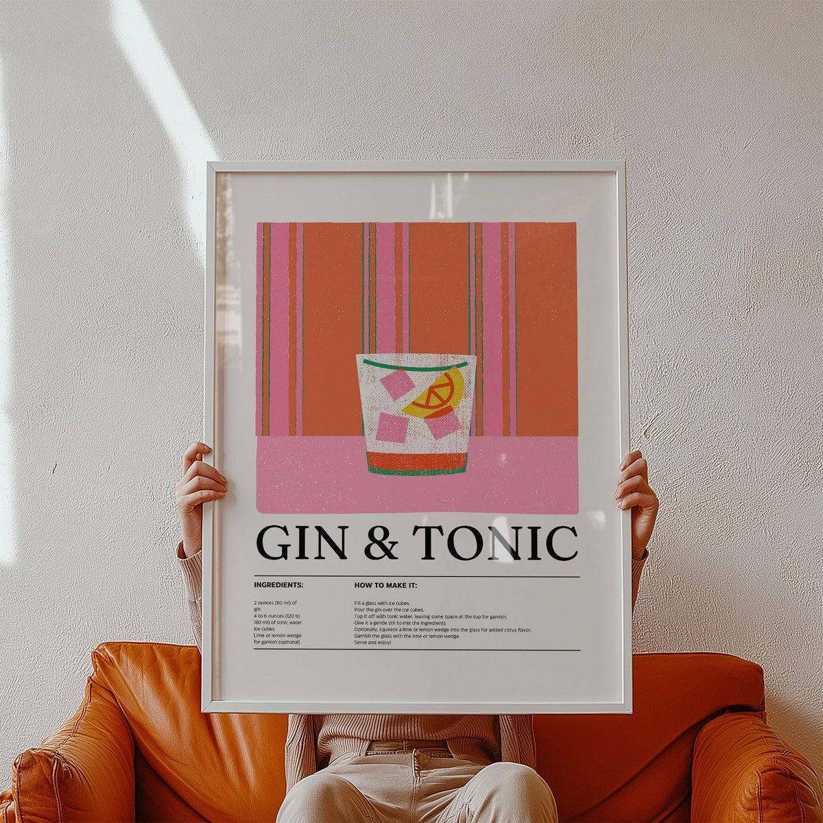 Kitchen art print of a gin and tonic cocktail with pink and orange colours held above a brown leather sofa