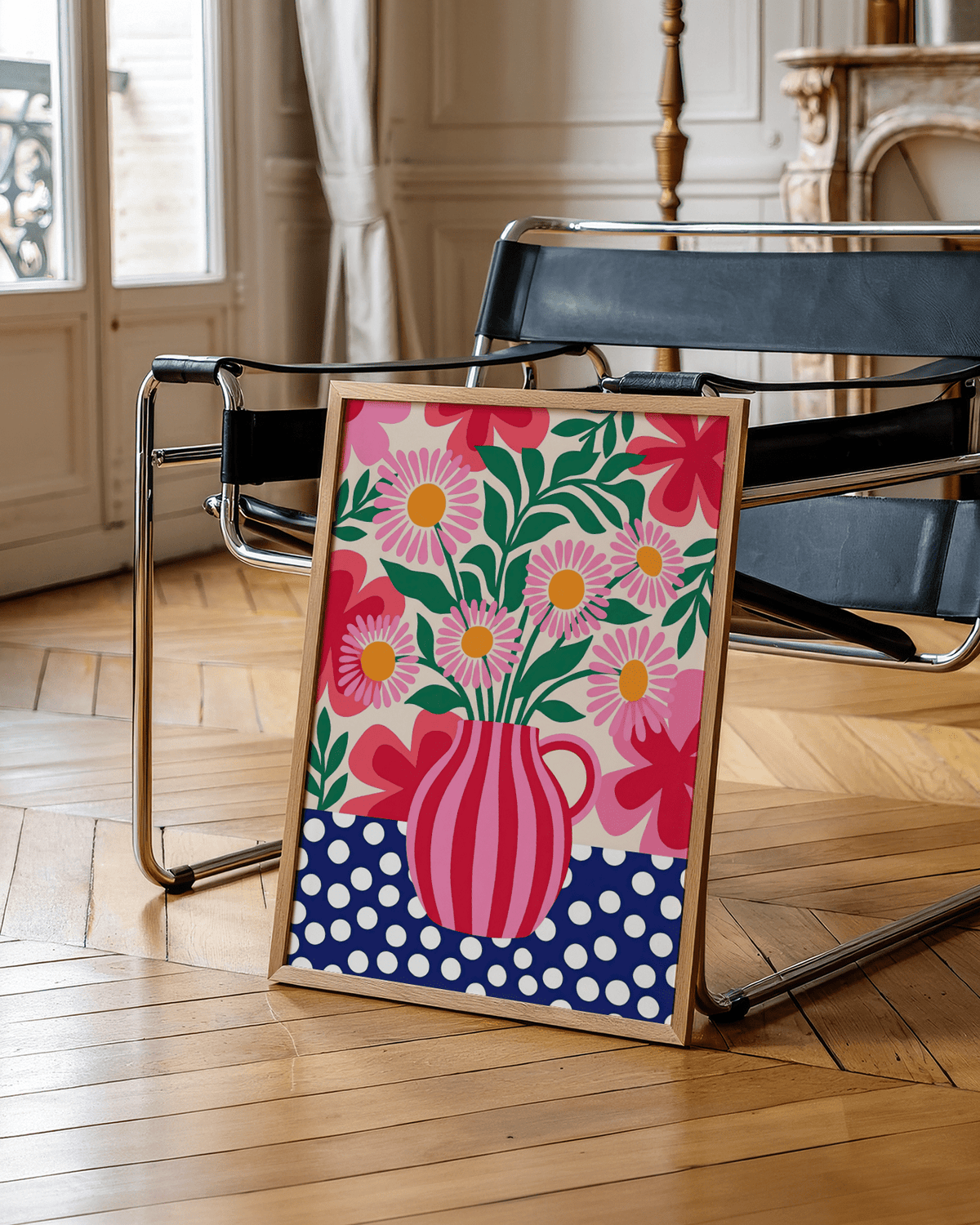 Colorful flower art print leaning on a black chair with wooden frame and a parquet floor