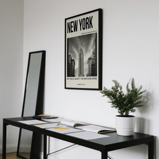 Empire State Building wall art with black and white photographic style hung above a desk with a potted plant