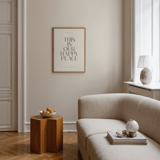 Inspirational wall sign with quote in a wooden frame above a wooden side table with a bowl of fruit in a living room
