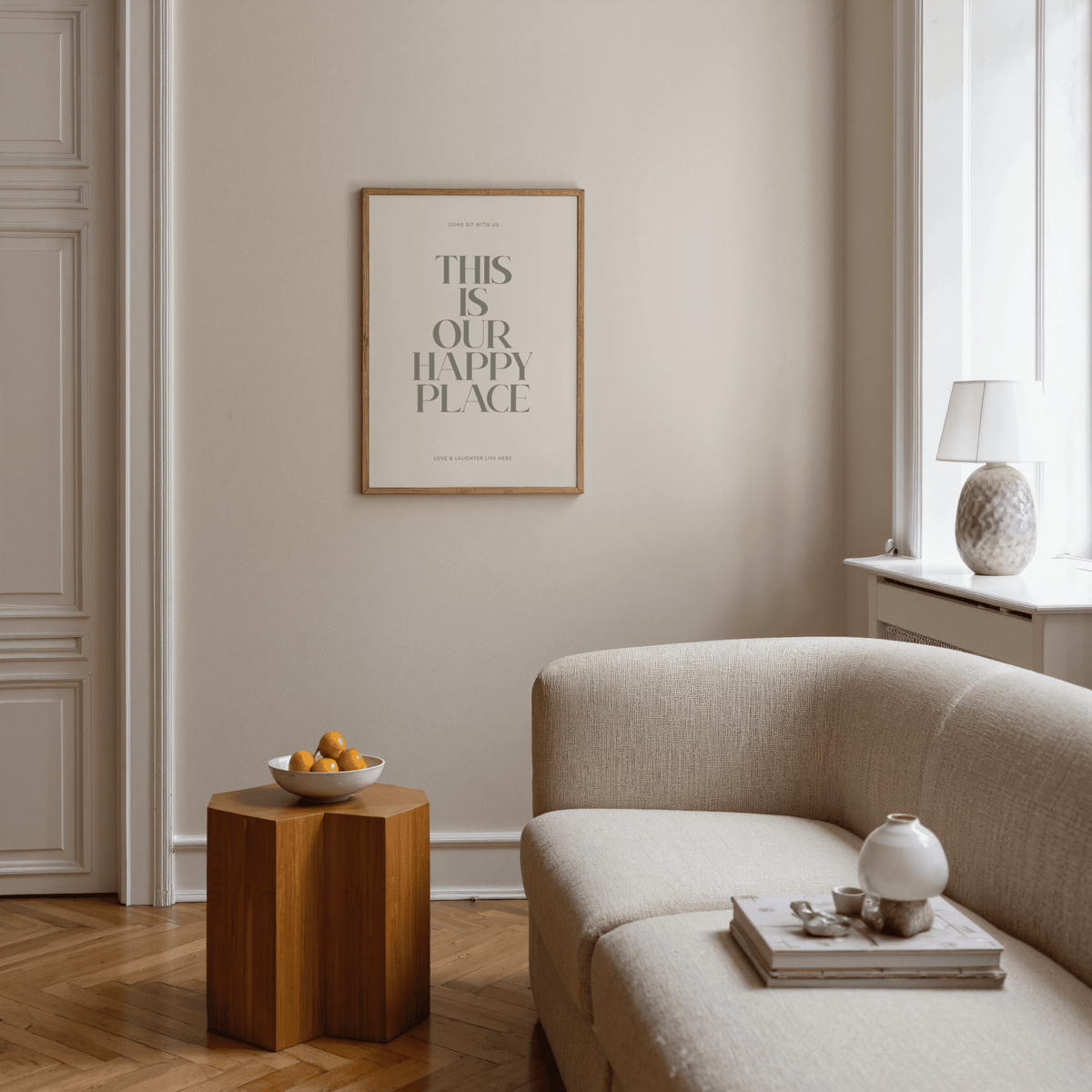 Inspirational wall sign with quote in a wooden frame above a wooden side table with a bowl of fruit in a living room