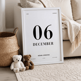 Print leaning on a floor beside a sofa and teddy bears with minimalist birth date details in black text