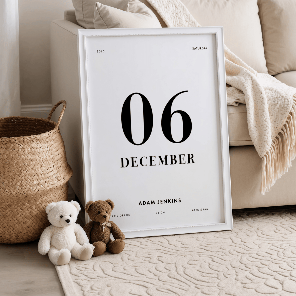 Print leaning on a floor beside a sofa and teddy bears with minimalist birth date details in black text
