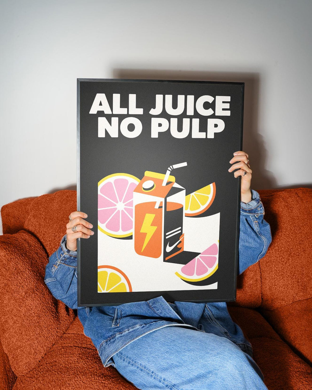 Pop Art Poster held by person on orange sofa vibrant orange juice carton with yellow lightning bolt