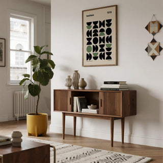 Gallery print of geometric bauhaus shapes in black and green above a sideboard with vases in a living room