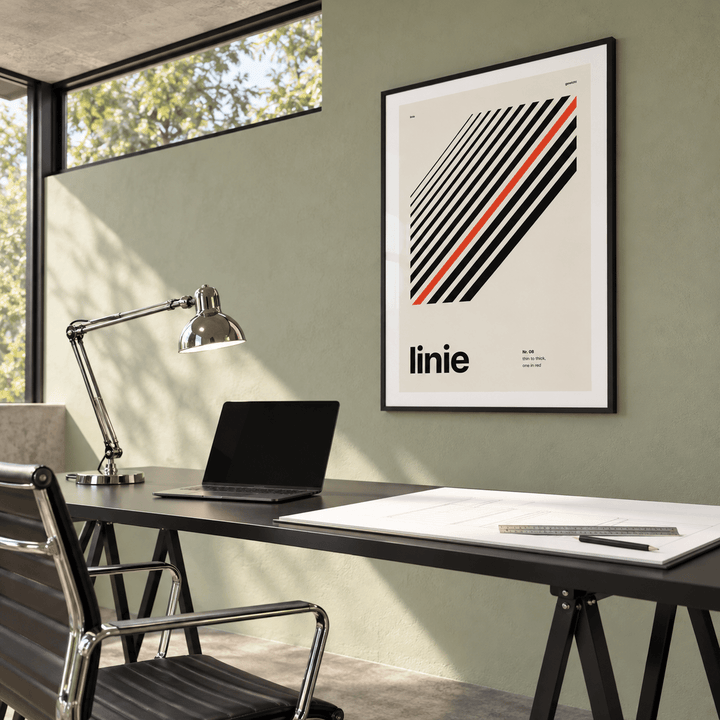 Parallel lines with one red line print above a desk in a home office