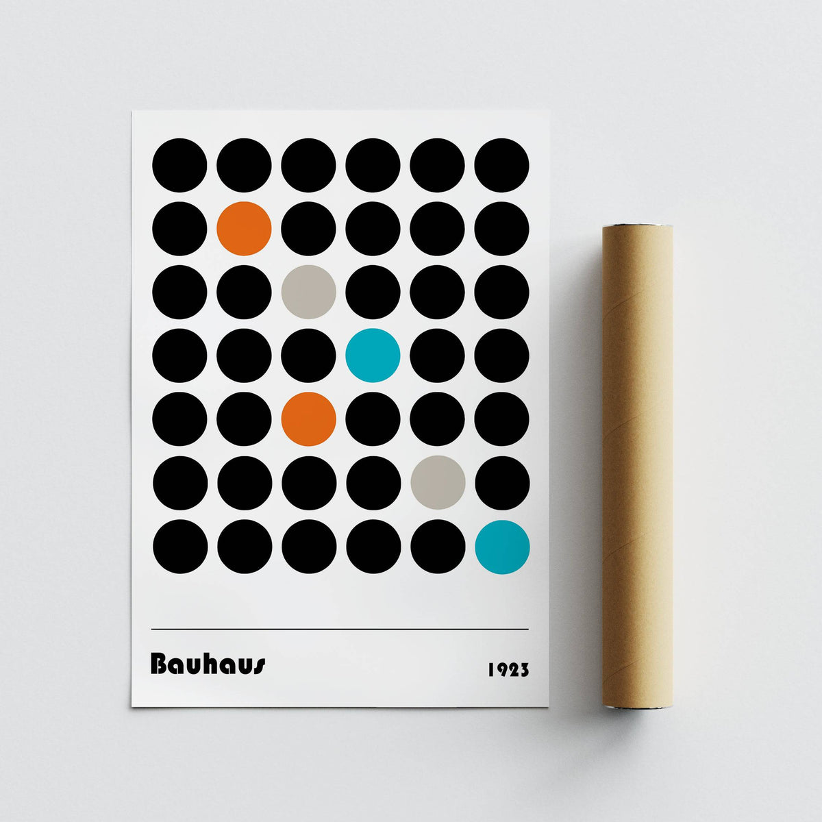 Graphic Prints of black and coloured dots with a brown packaging tube on white surface
