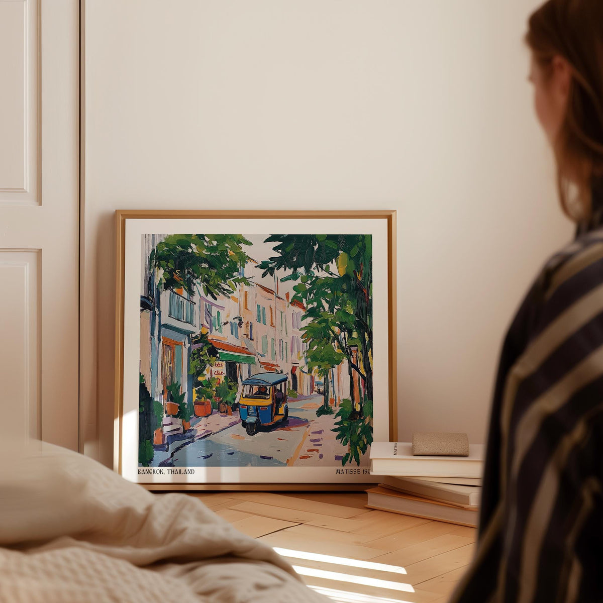 Framed Holiday Prints leaning on floor with colourful tuk-tuk street scene and green foliage