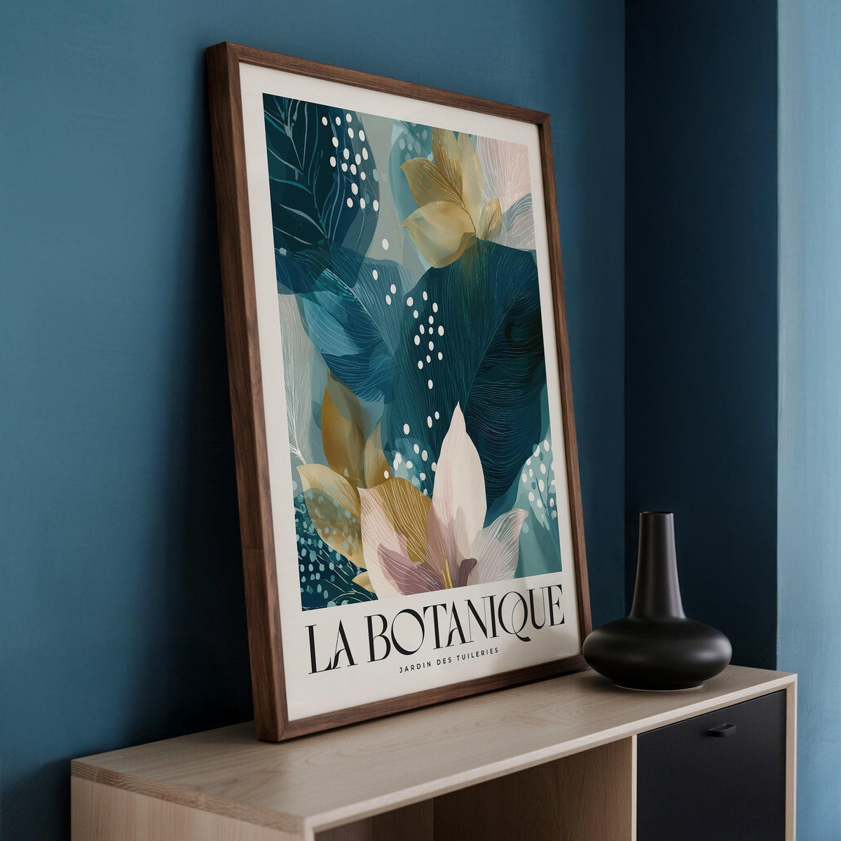 Print leaning on a shelf botanical artwork print with blue leaves and white flowers beside a black vase