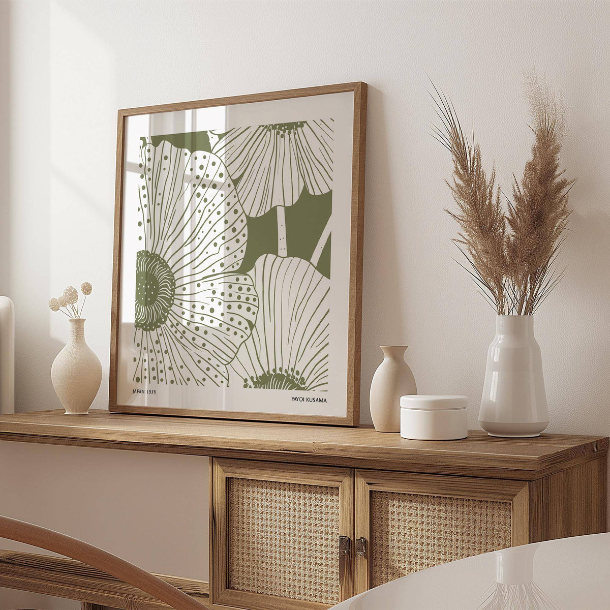 Framed print Sage Green Abstract Wall Art with stylised poppy flowers on a wooden sideboard with vases