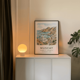 Print of Muscat art showing a watercolour cityscape with sandy hills beside a white lamp on a sideboard