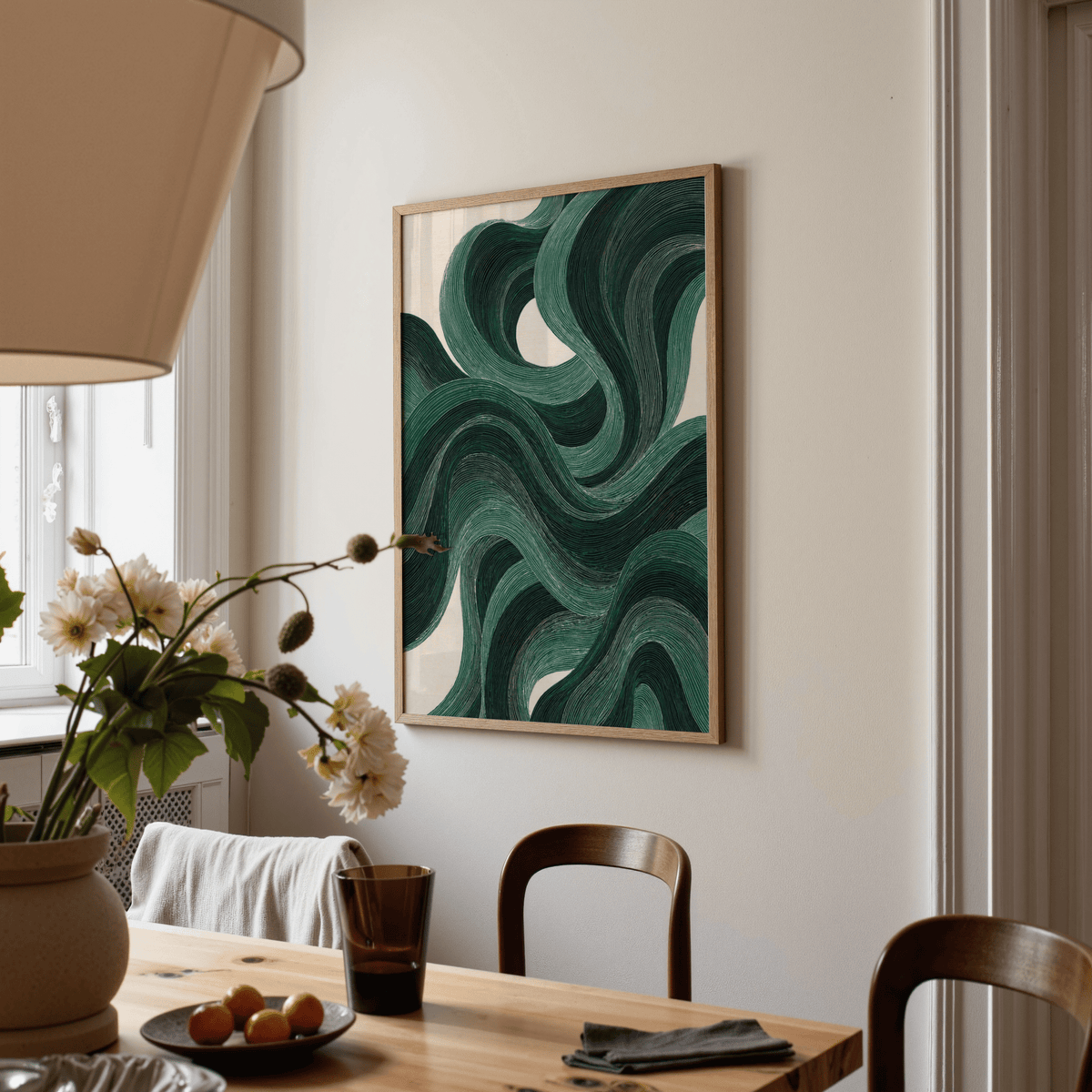 Print on a wall in a dining room with a modern swirl poster showing a green abstract pattern and a flower vase on the table