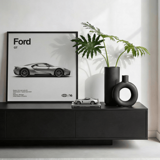 American Supercar wall art leaning on a black sideboard with a black vase and plant beside it