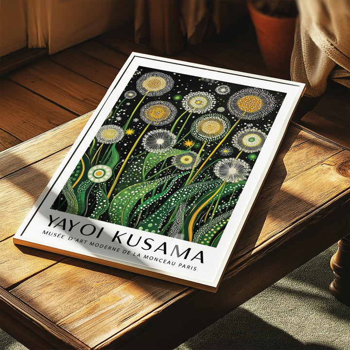 Print of golden dandelions illustration laid on a wooden table with sunlight and a plant pot nearby