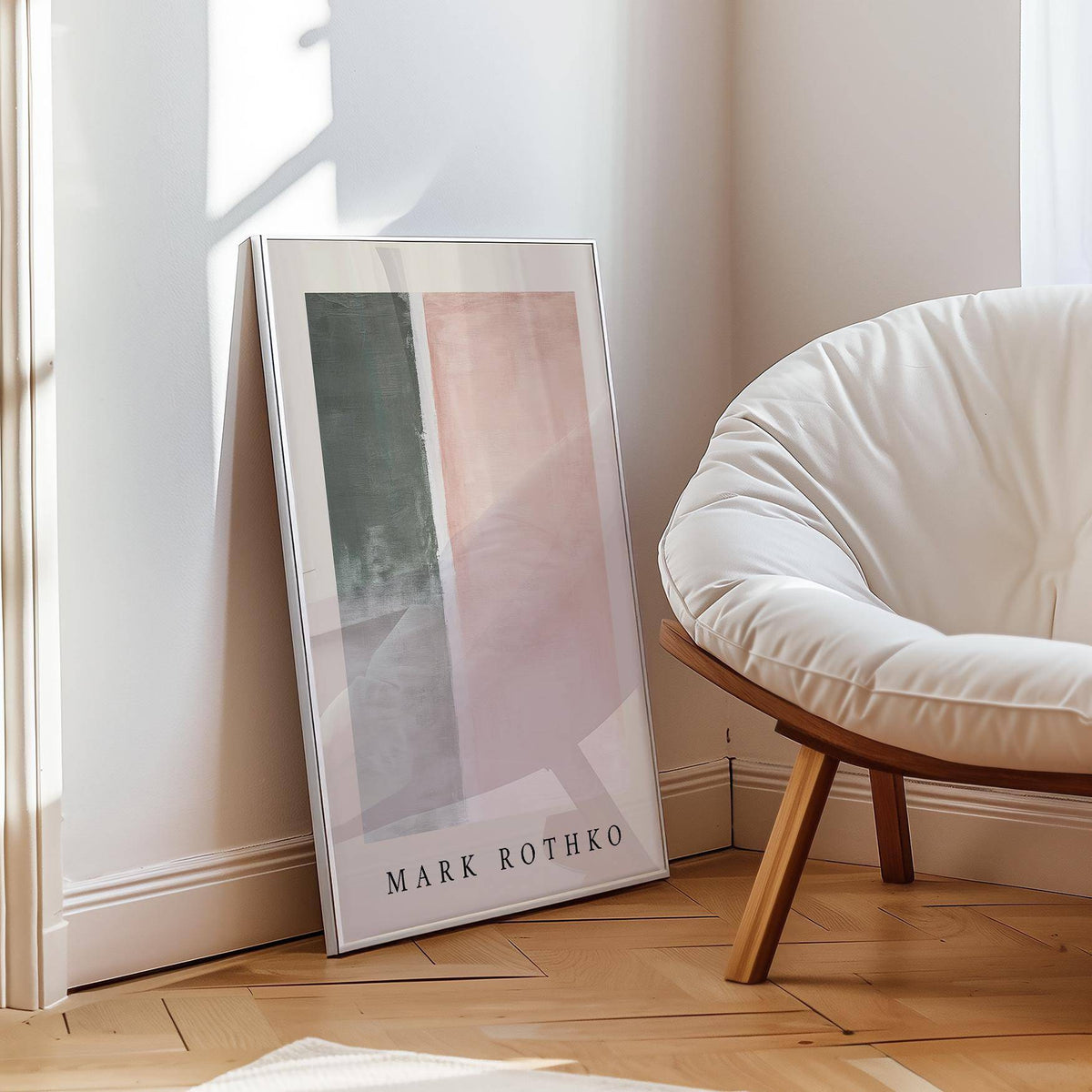 Framed art wall painting with abstract pastel blocks in pink and grey leaning on the floor near a white chair