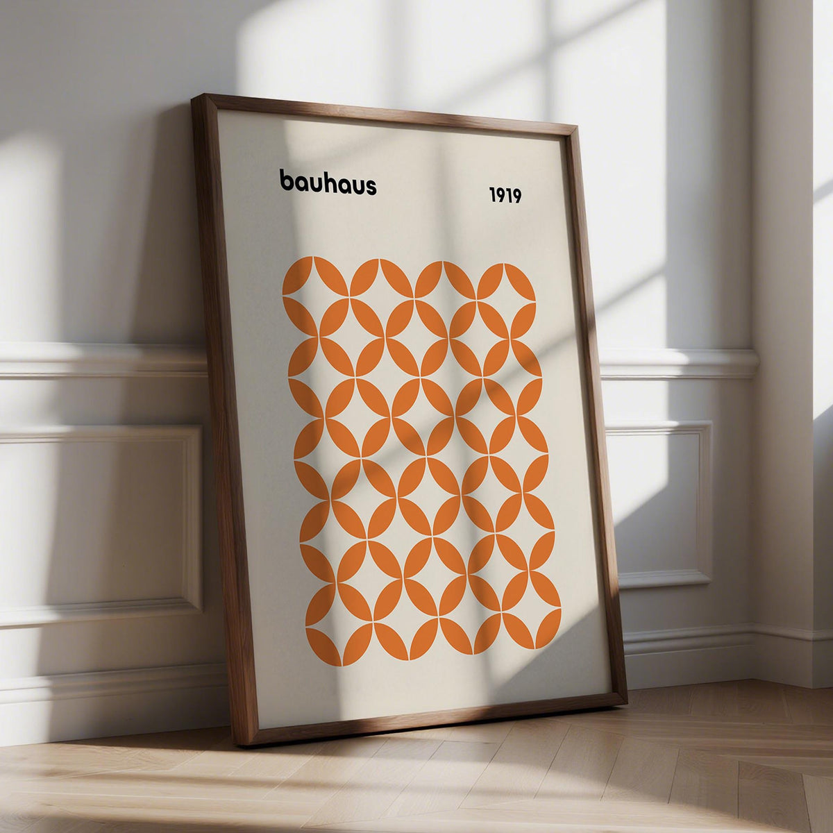 Print leaning on a floor with orange circle pattern in a minimalist style and natural light