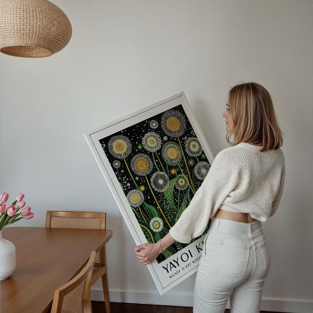 Framed Botanical Wall Art held by a woman with golden dandelions on a black background in a white frame