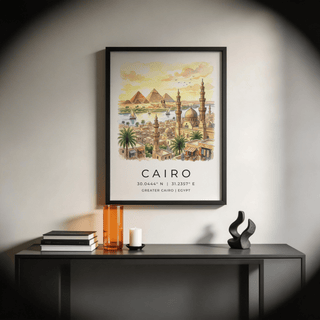 Framed Cairo Landscape wall art in black frame above a black console table with books and decorative objects