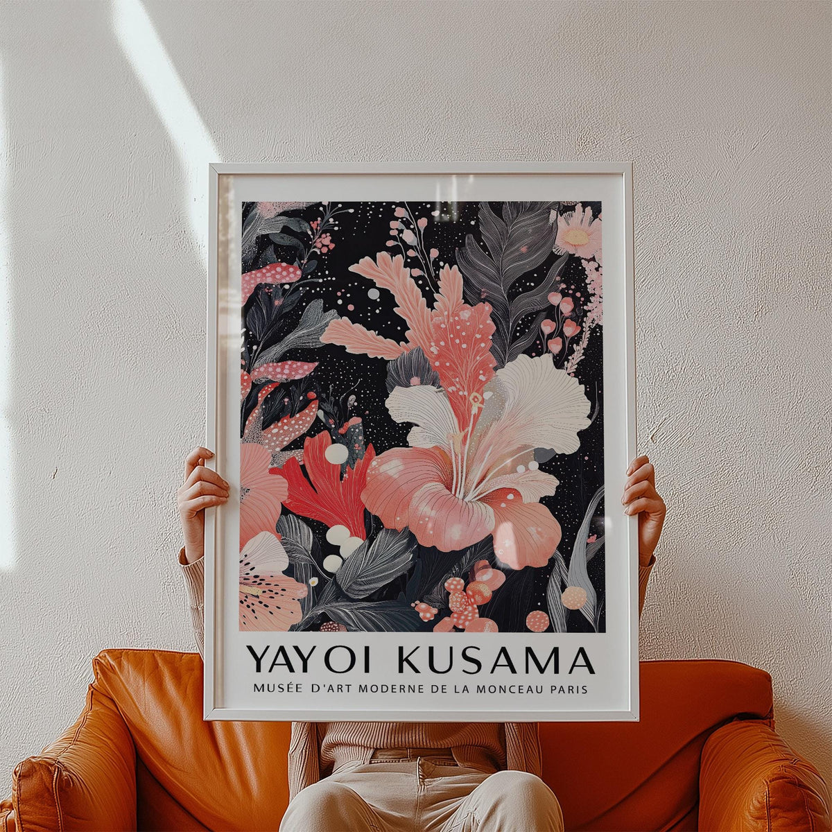Black and Pink Wall Art held against white wall above a brown leather sofa