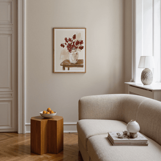 Red Berries poster hung above a wooden side table with a bowl of fruit in a beige living room