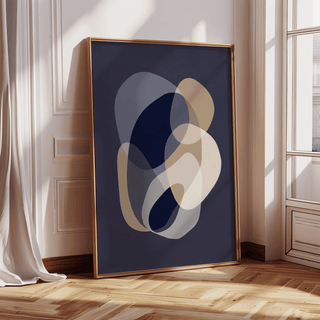 Print leaning with abstract organic shapes in beige and navy by a window with sunlight and curtain