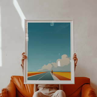 Framed Bicycle Journey wall art of a cyclist on a vibrant road with orange fields held by person
